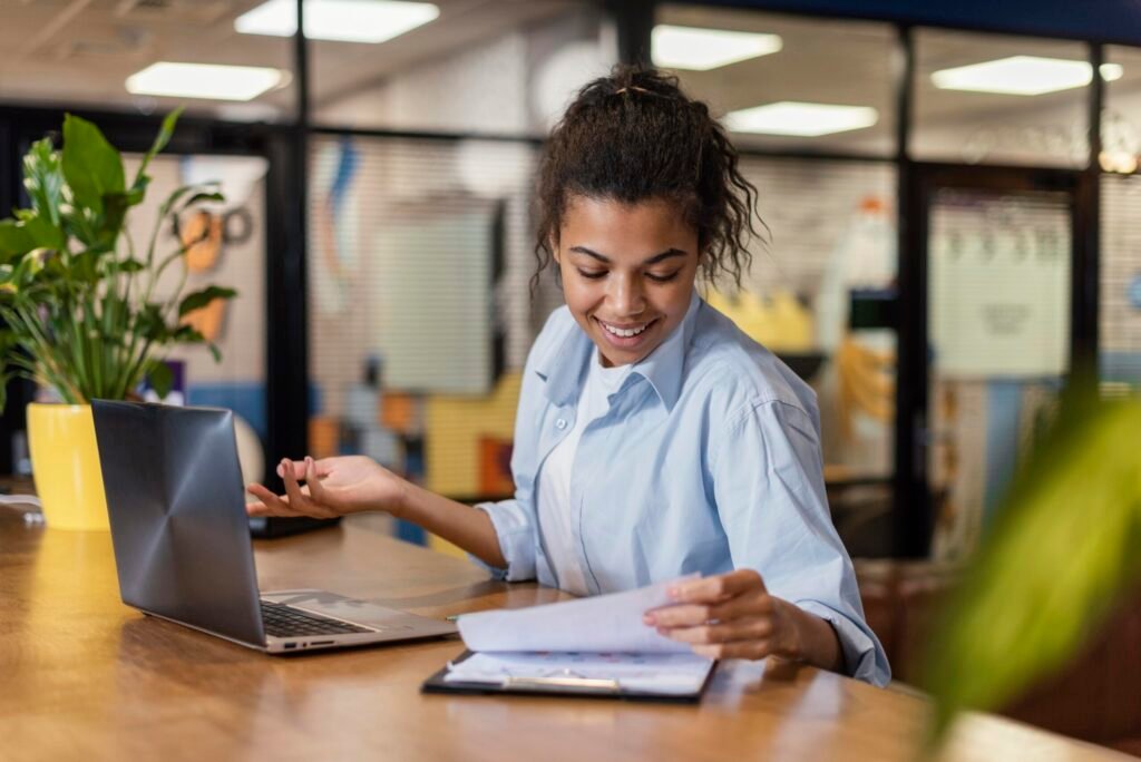 smiley-woman-working-office-with-papers-laptop